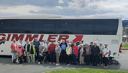 Gruppenfoto Reise Marburg Gruppe älterer Menschen steht vor einem großen Reisebus mit der Aufschrift 'GIMMLER'